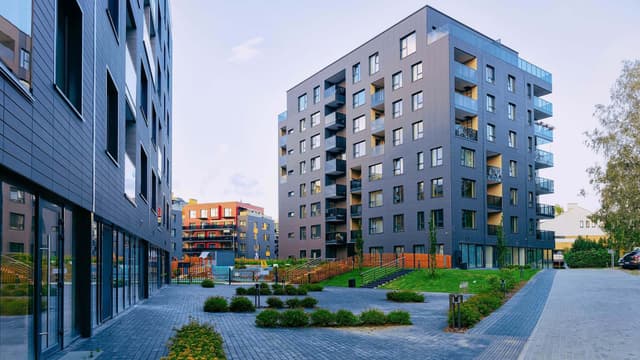 Tiiliverhoiltu kerrostalo kaupunkimaisemassa geonova