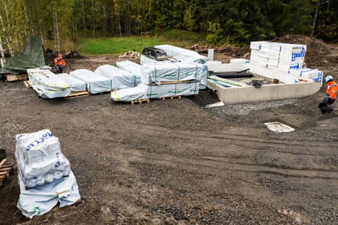 <p data-block-key="fsphm">Autotallin katos päätettiin rakentaa ensimmäisenä, koska siitä tulisi arvokasta säilytystilaa mm. eristeille. Tavaratoimitus purettiin siksi tulevan tulevan autotallin lähelle.</p>