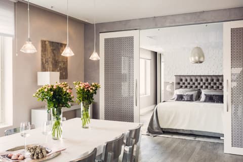 <p data-block-key="cvg8a">Ruokailutila on sijoitettu keittiötä vastapäätä. Seinillä olevat taulut ovat myös valaisimia.</p>