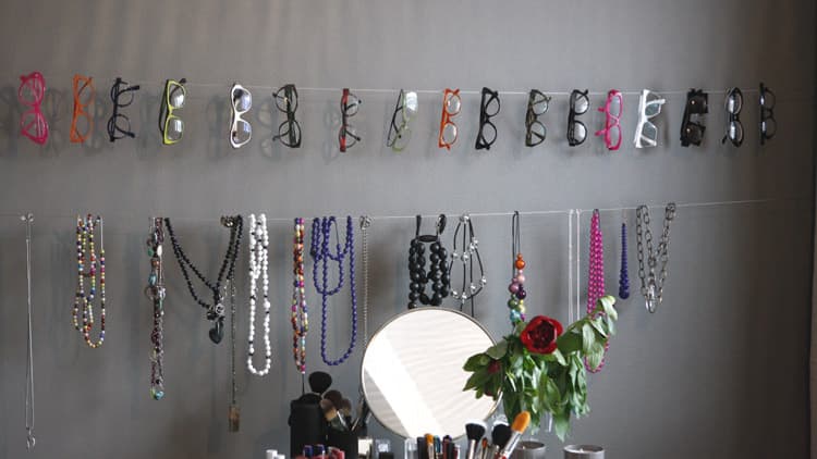<p data-block-key="dutry">Meikkitaiteilijan työhuoneen seinä on otettu hyötykäyttöön. Seinälle kiinnitettyihin vaijereihin on helppo ripustaa esille vaikka koruja.</p>