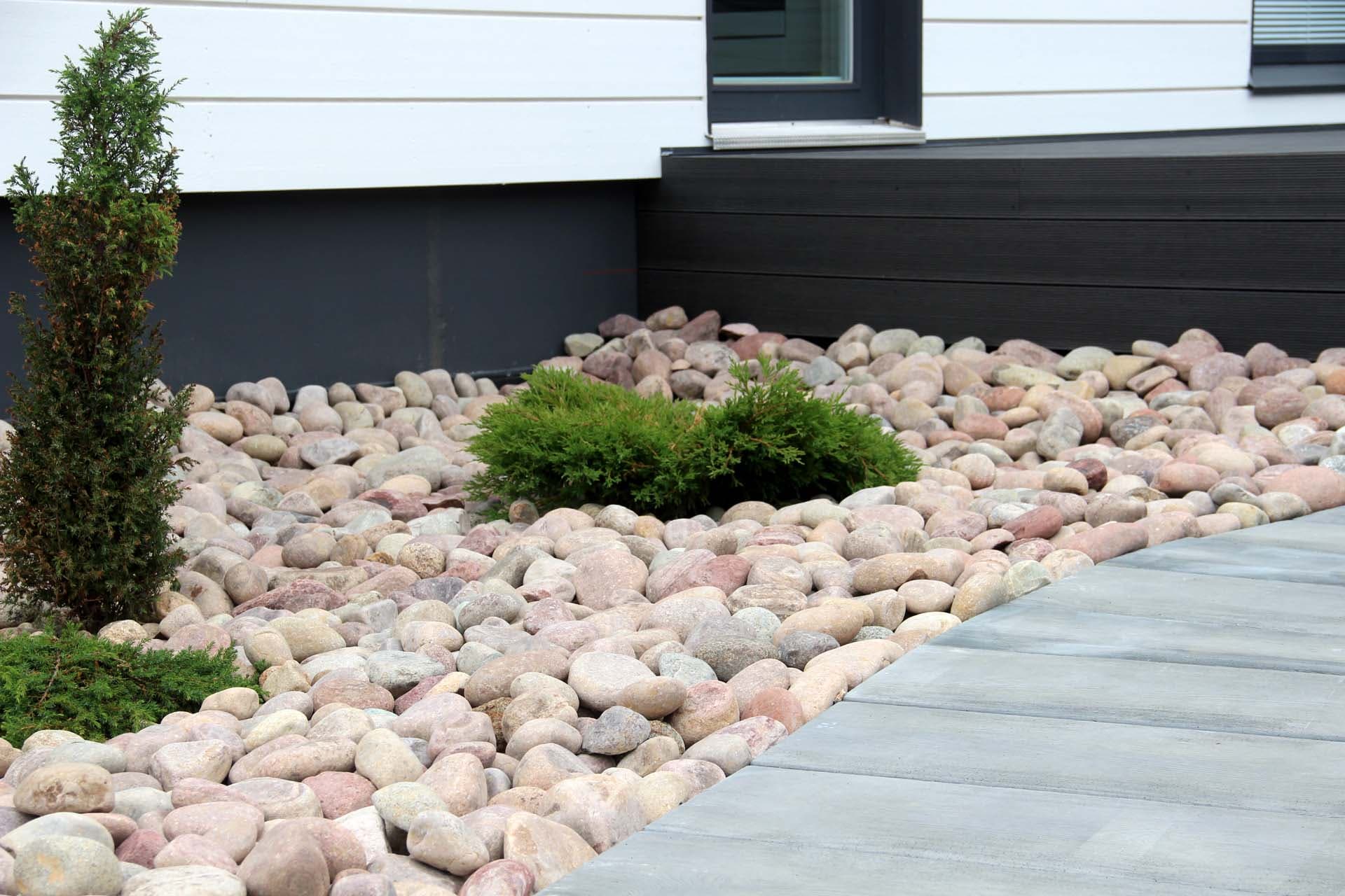 <p data-block-key="27i5k">Laaja mukulakivialue, johon on istutettu havuja.</p>