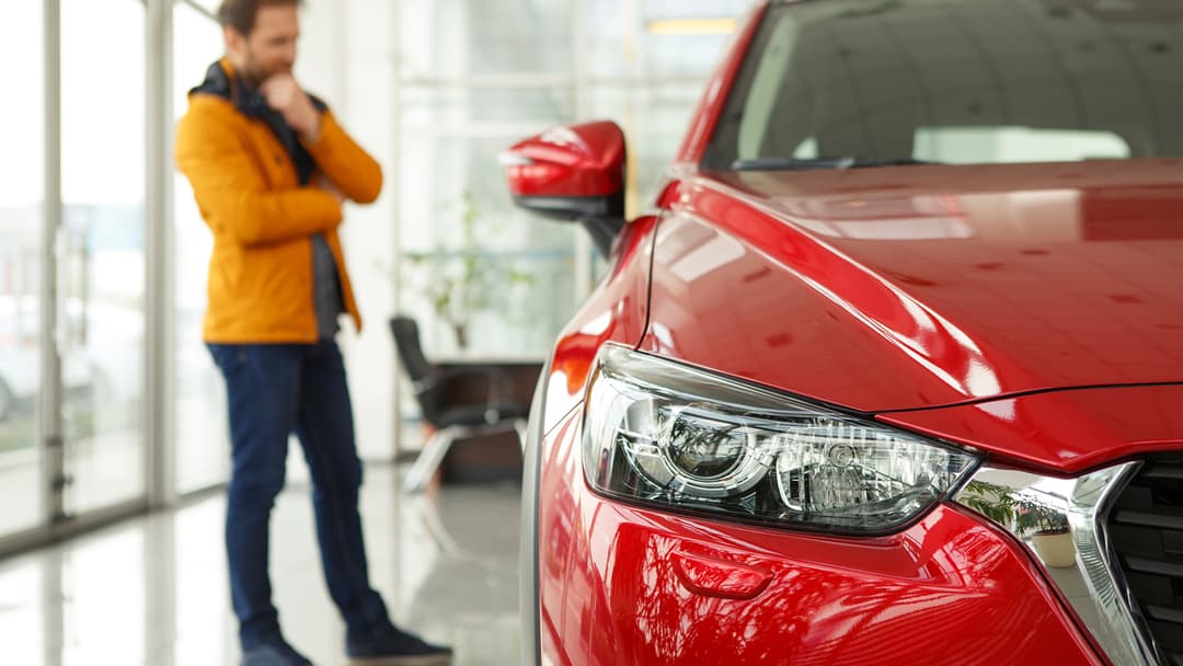 mies miettii sähköauton ostamista autoliikkeessä