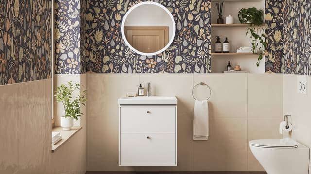 kylpyhuone, jossa seinä wc, lavuaari pienellä allaskaapilla sekä pyöreä seinäpeili
