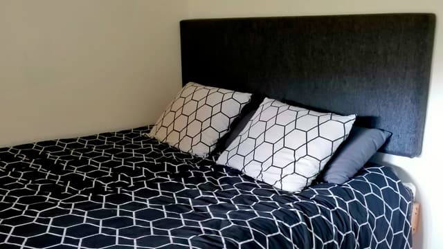 Korkea sänky ja itse tehty sängyn pääty