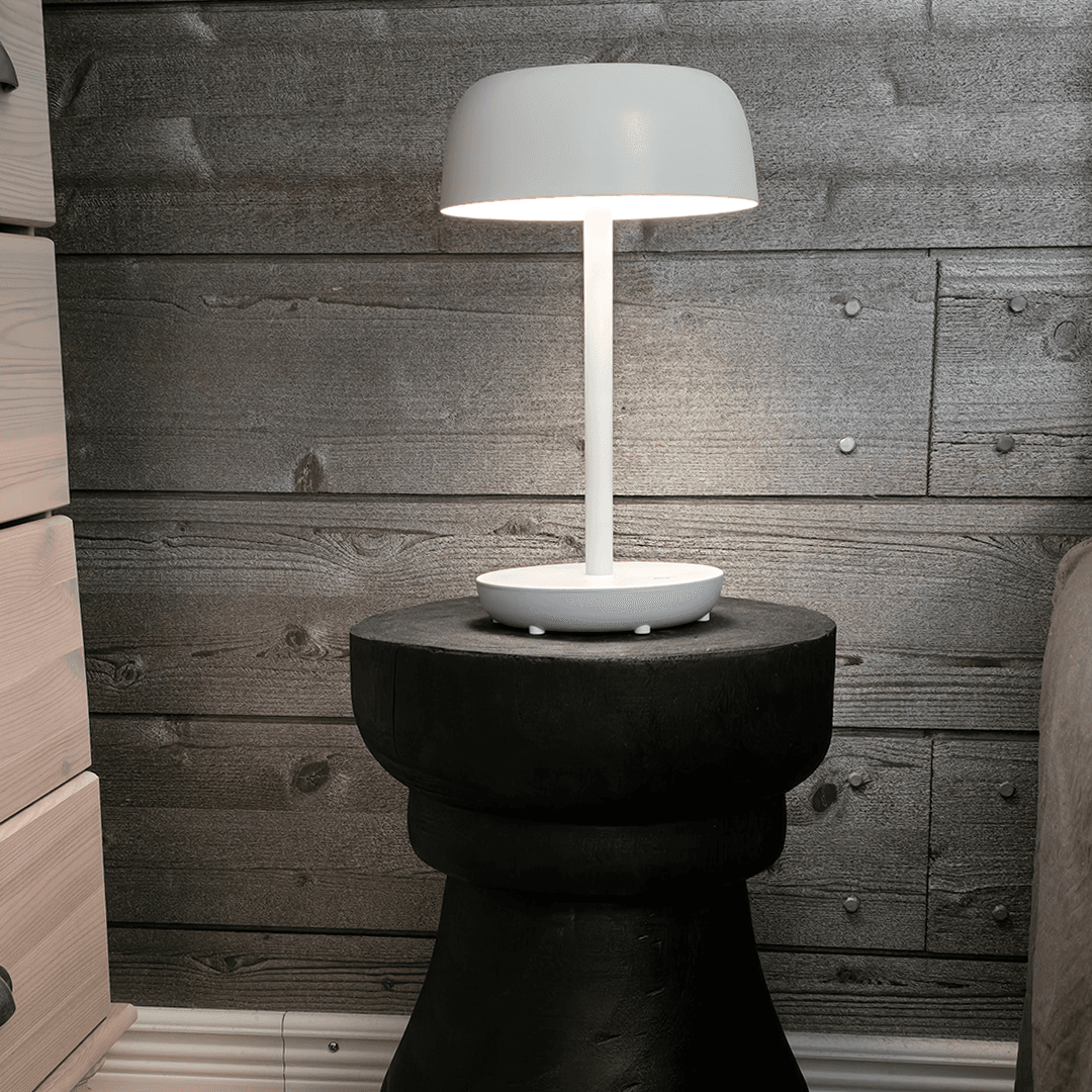 jukevä musta yöpöytä ja valkoinen lamppu