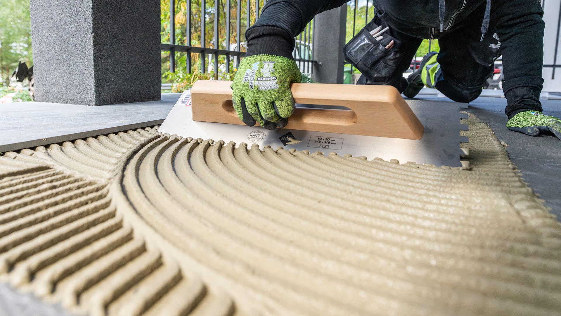 Weberin kiinnityslaastin levitys terassin pintaan käyttäen hammaslastaa.