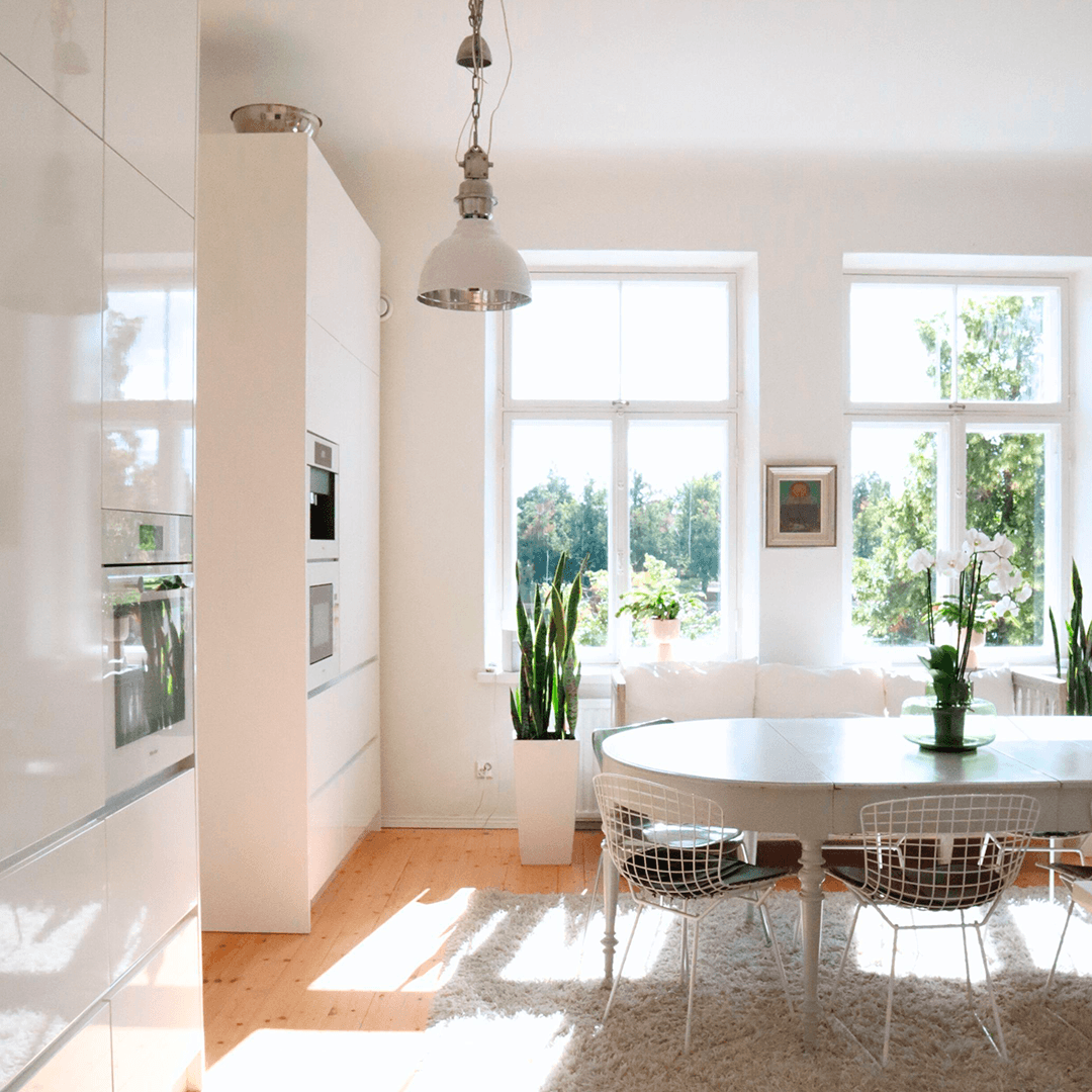 kaksi suurta korkeaa ikkunaa keittiön pöydän takana