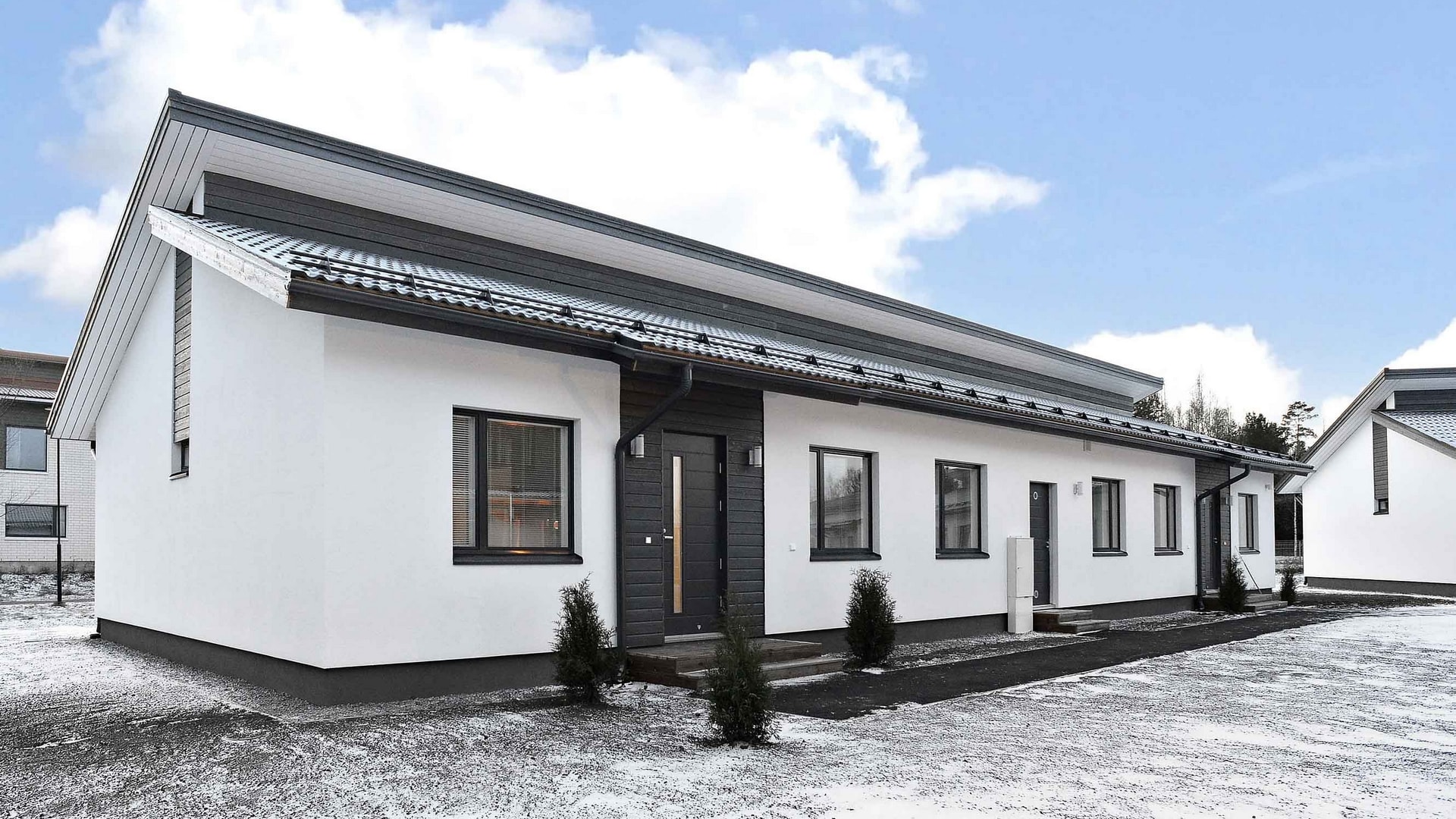 Valkoinen omakotitalo mustilla tehosteilla