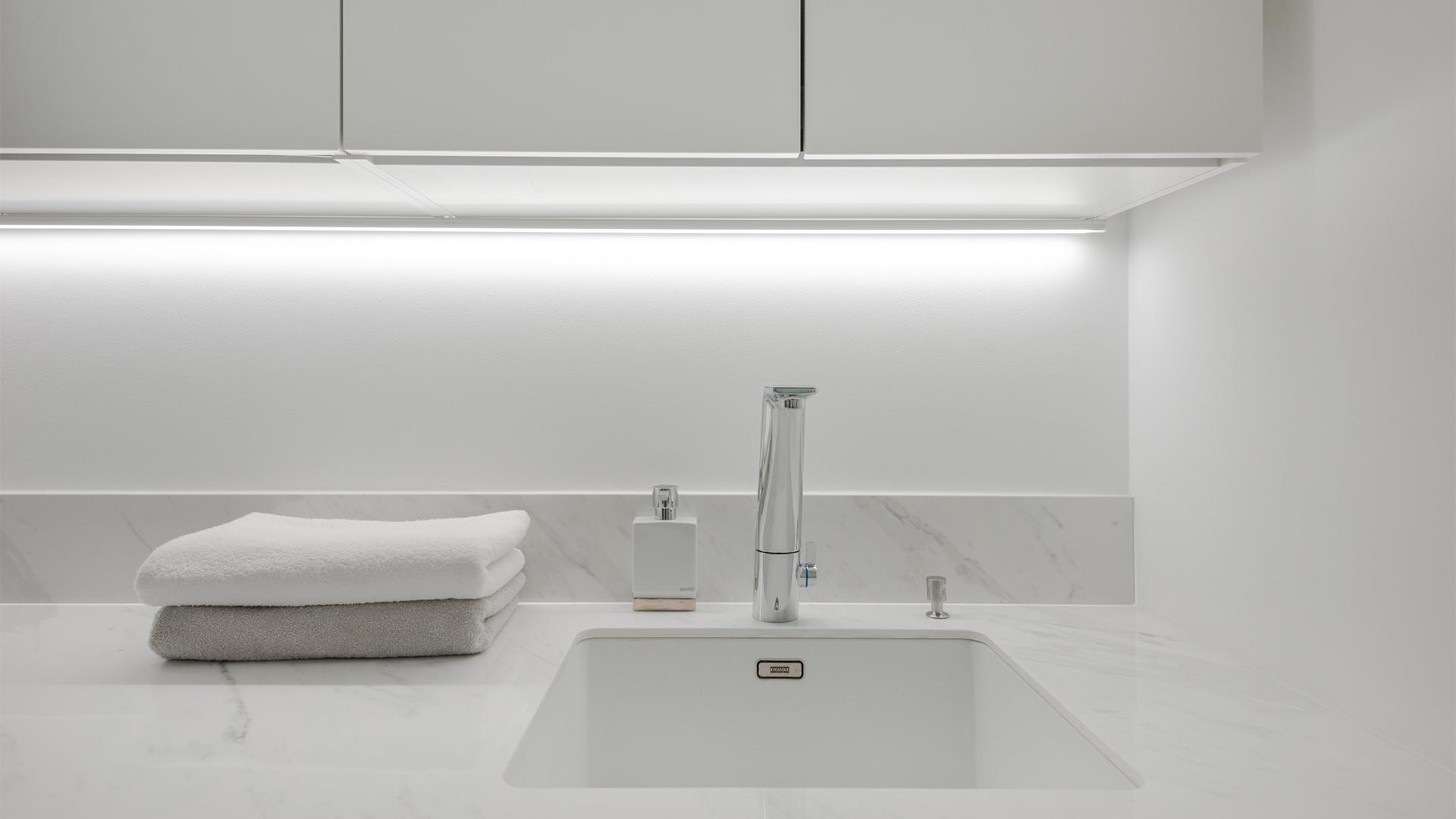 Kodinhoitohuoneen työtasolle tasaista valoa tuo kaapiston takaosaan asennettu valkoinen led-kisko, jossa neutraalin 4000K värisävyinen led-nauha. (kuva: LedStore ja Erika Luoto)