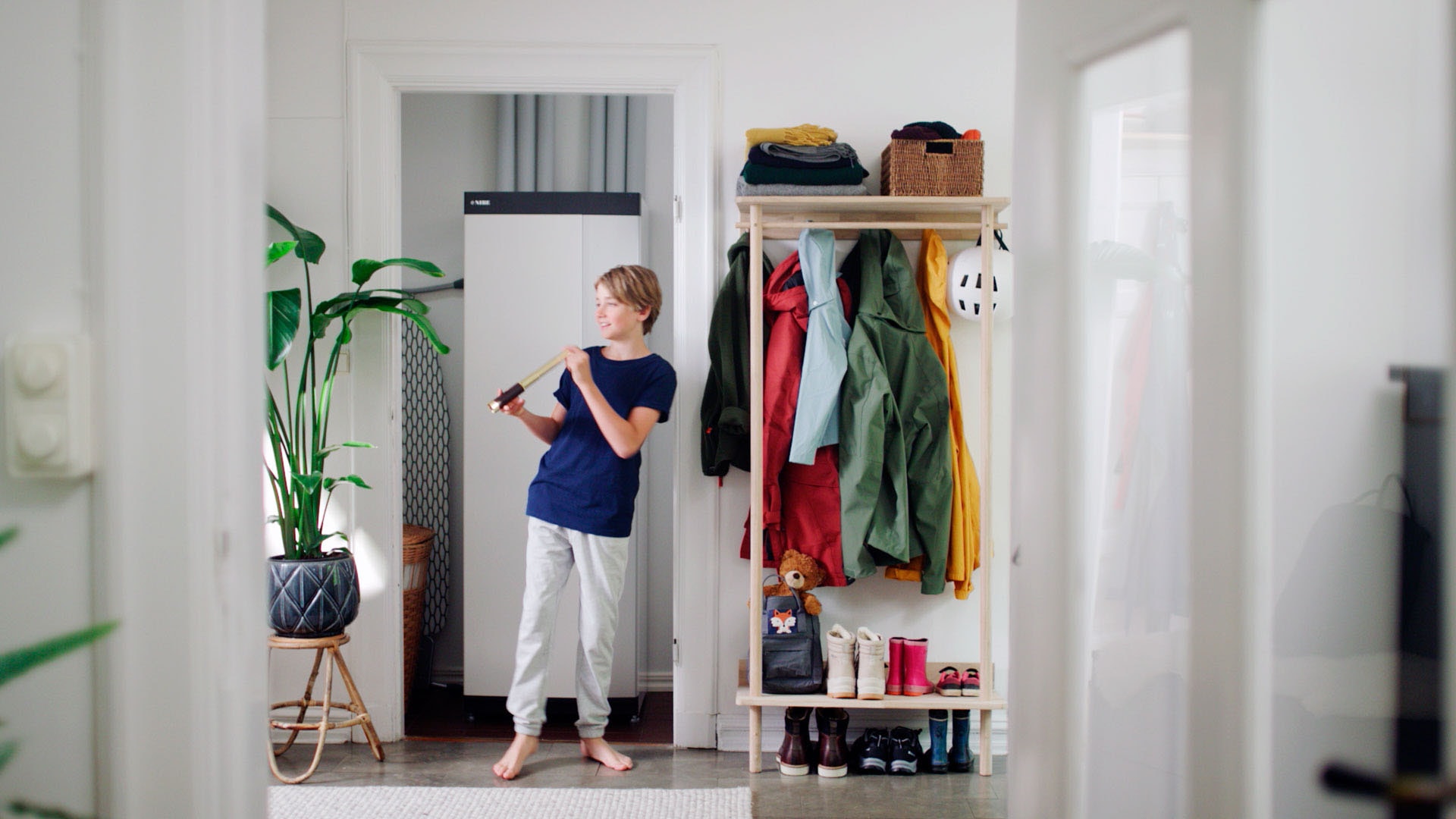 1920 Nuori poika soittaa huilua NIBEn lämpöpumpun edessä