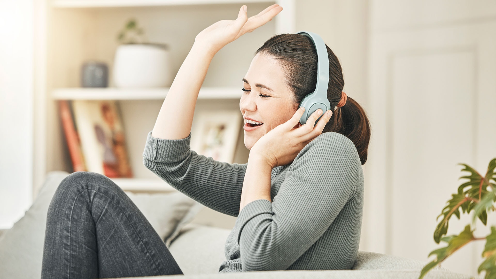 1920 huolettoman oloinen ja iloinen nainen kuuntelee musiikkia kuulokkeilla