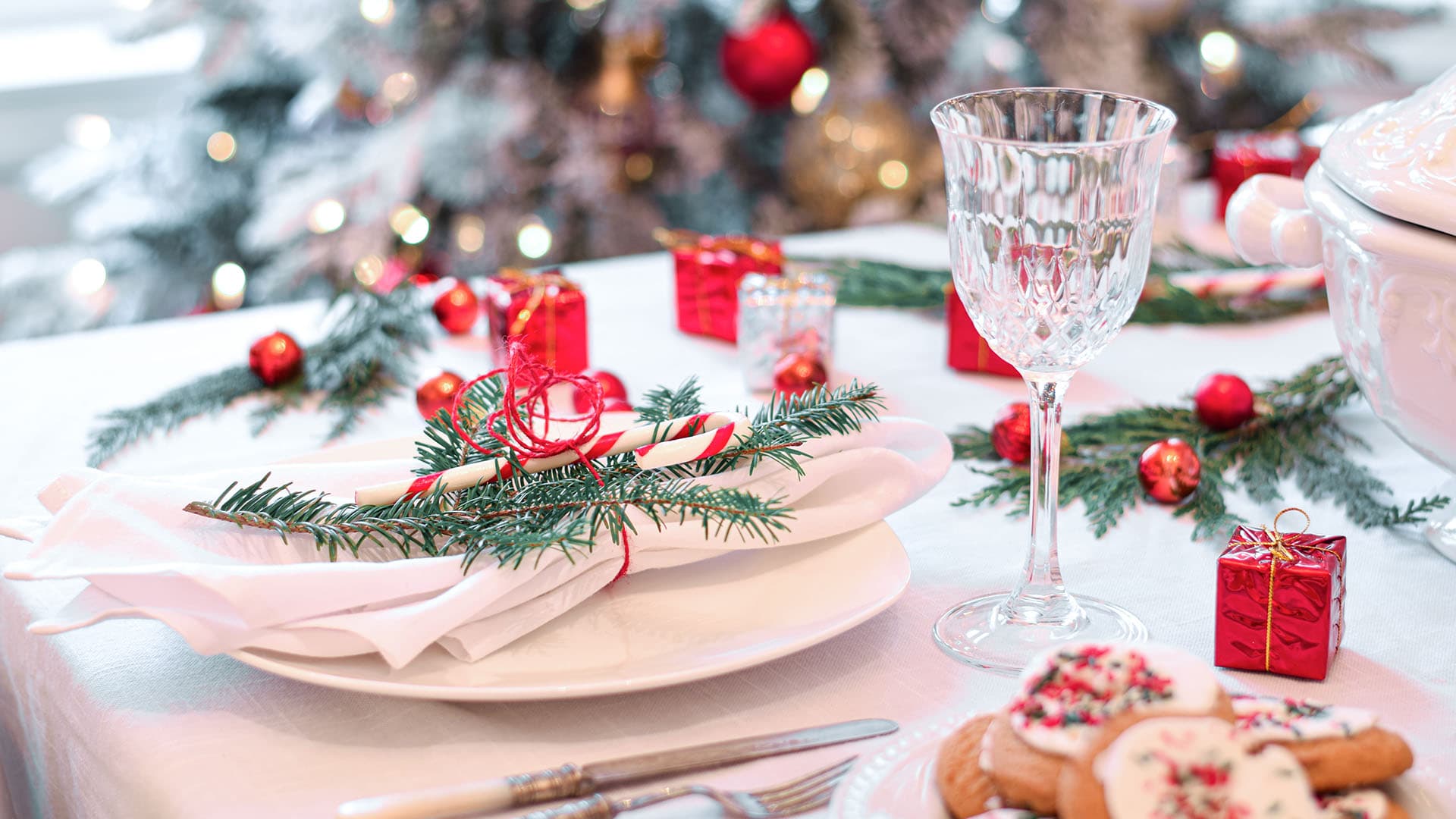 jouluinen kattaus, jossa taustalla joulukuusi