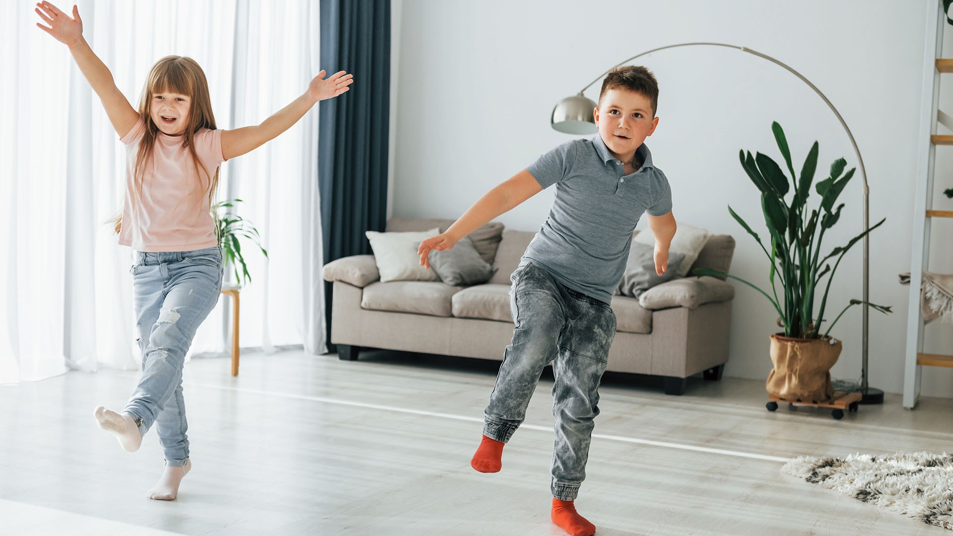 1920 kaksi lasta hyppimässä ja tanssimassa olohuoneessa