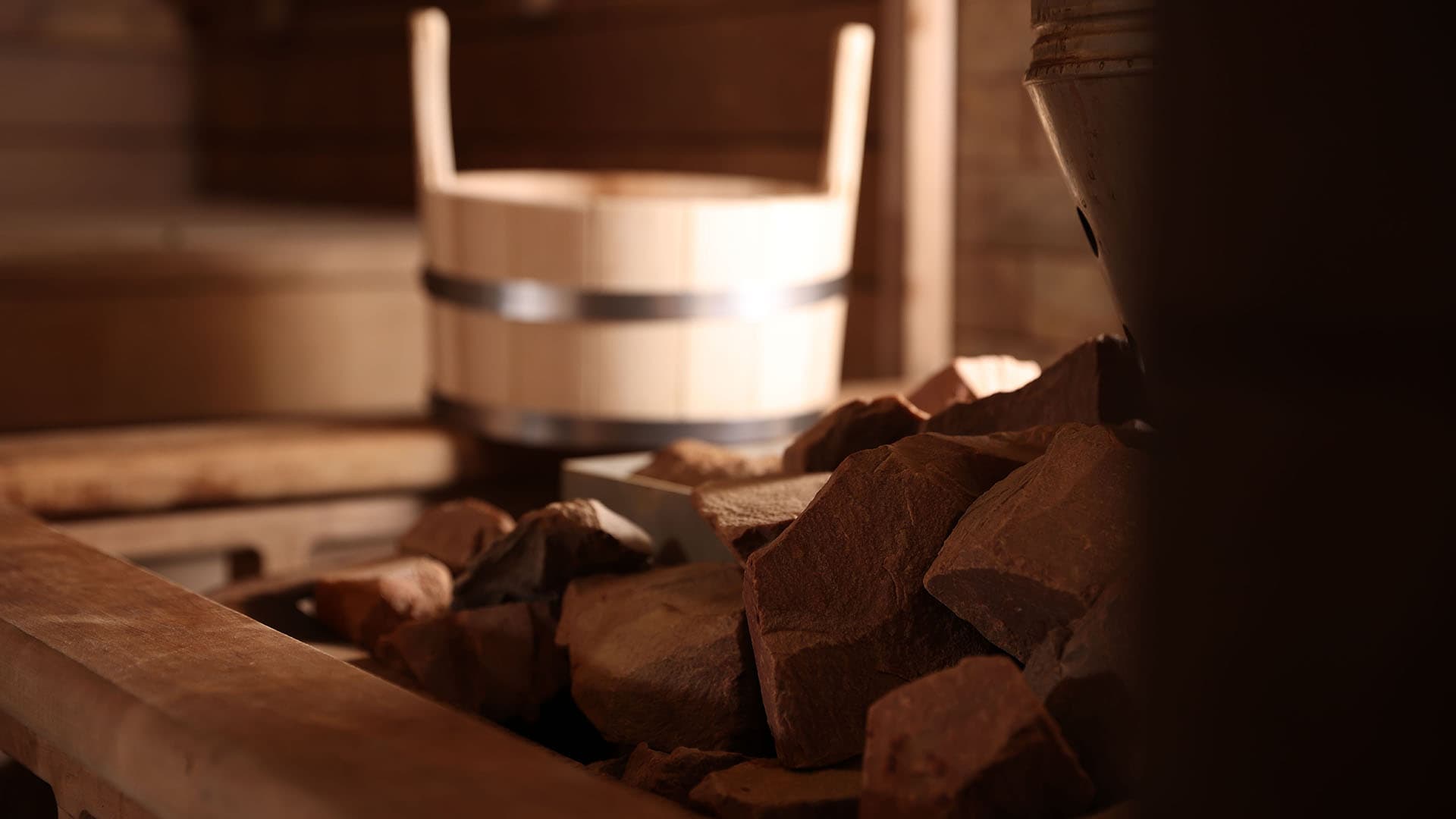 kiuas etualalla taustalla kiulu ja lauteet