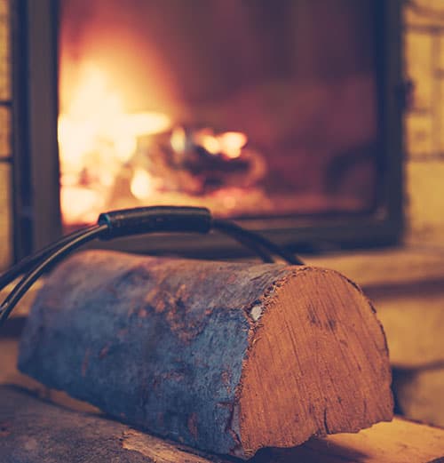 kuivia polttopuita puukorissa takan edustalla