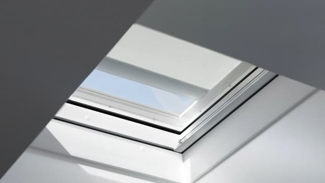 Tasakaton kattoikkuna, jossa lämmönkestävä verho osittain auki.