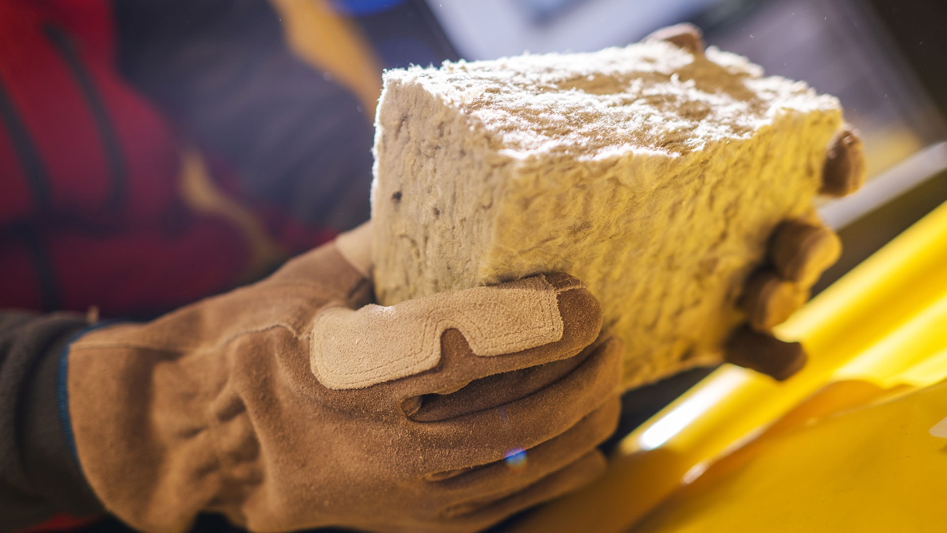 1920 mies pitää kädessään pientä palaa mineraalivillaa