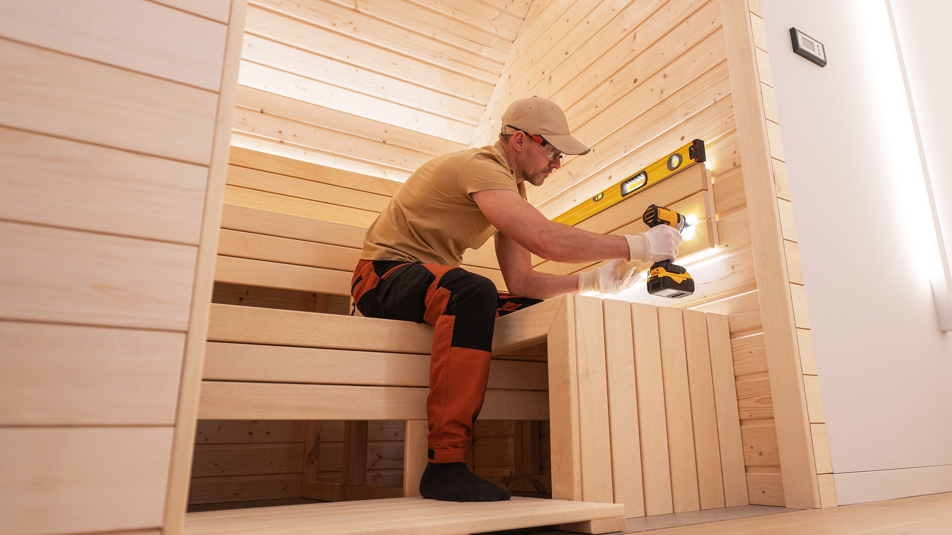 1920 mies rakentaa saunaa ja asentaa saunan lauteita