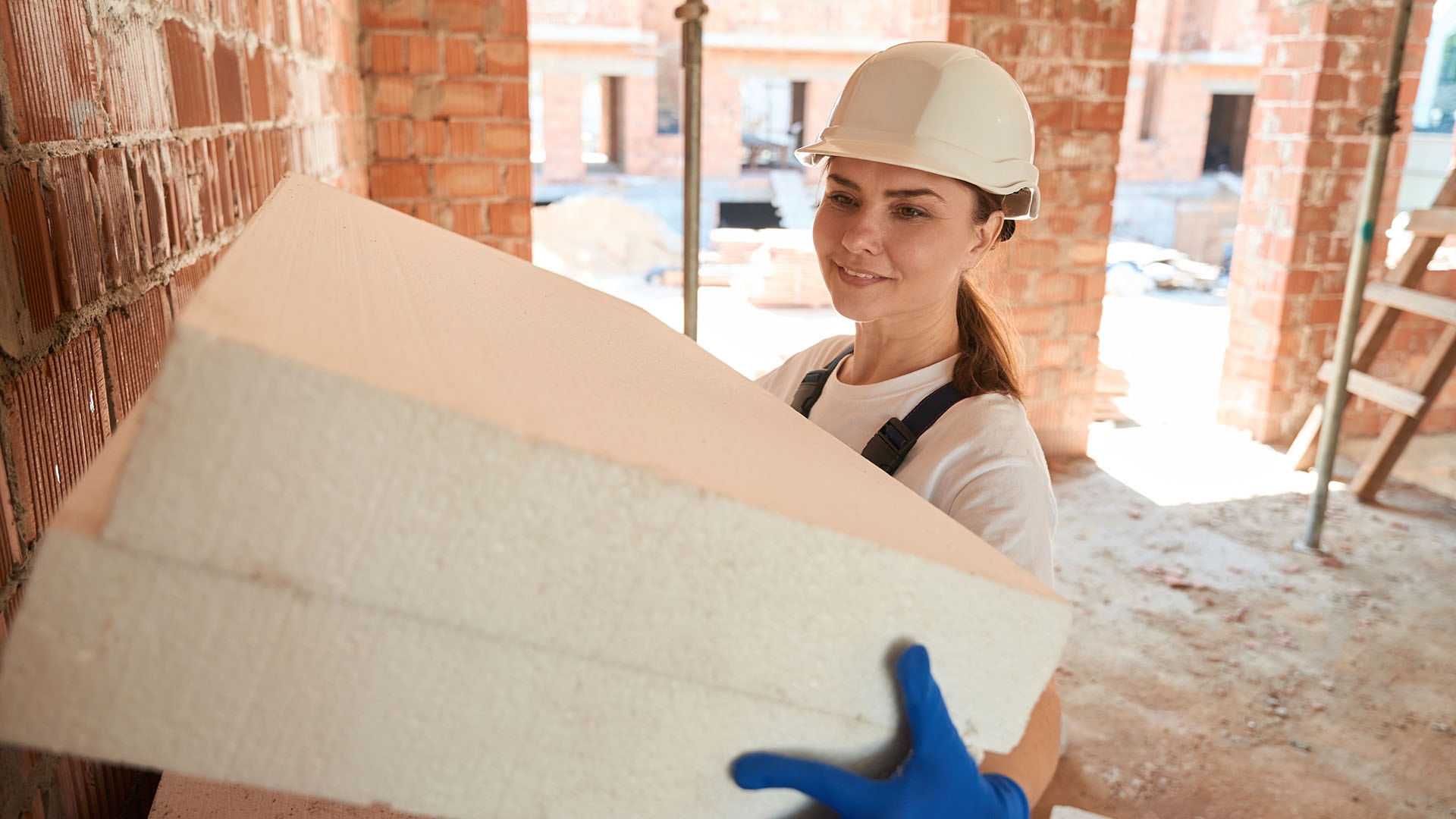 1920 nainen kantaa kahta eristelevyä työmaalla