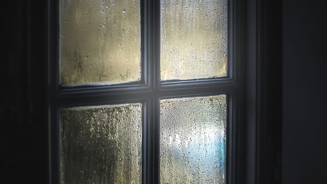 puinen neliruutuinen ikkunanpoka, jonka lasipinnassa tiivistynyttä kosteutta