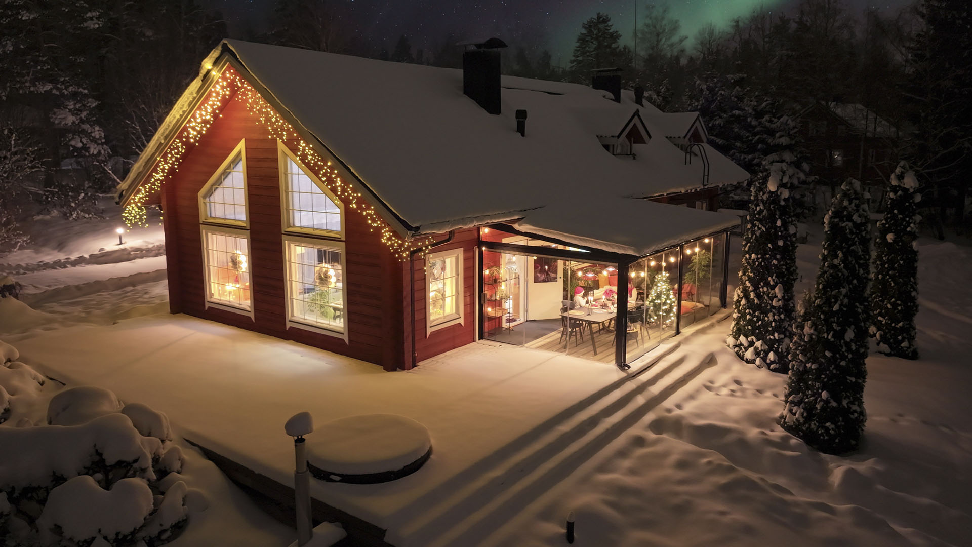 1920 punainen lumonin lasiterassilla varustettu talo talvisessa maisemassa