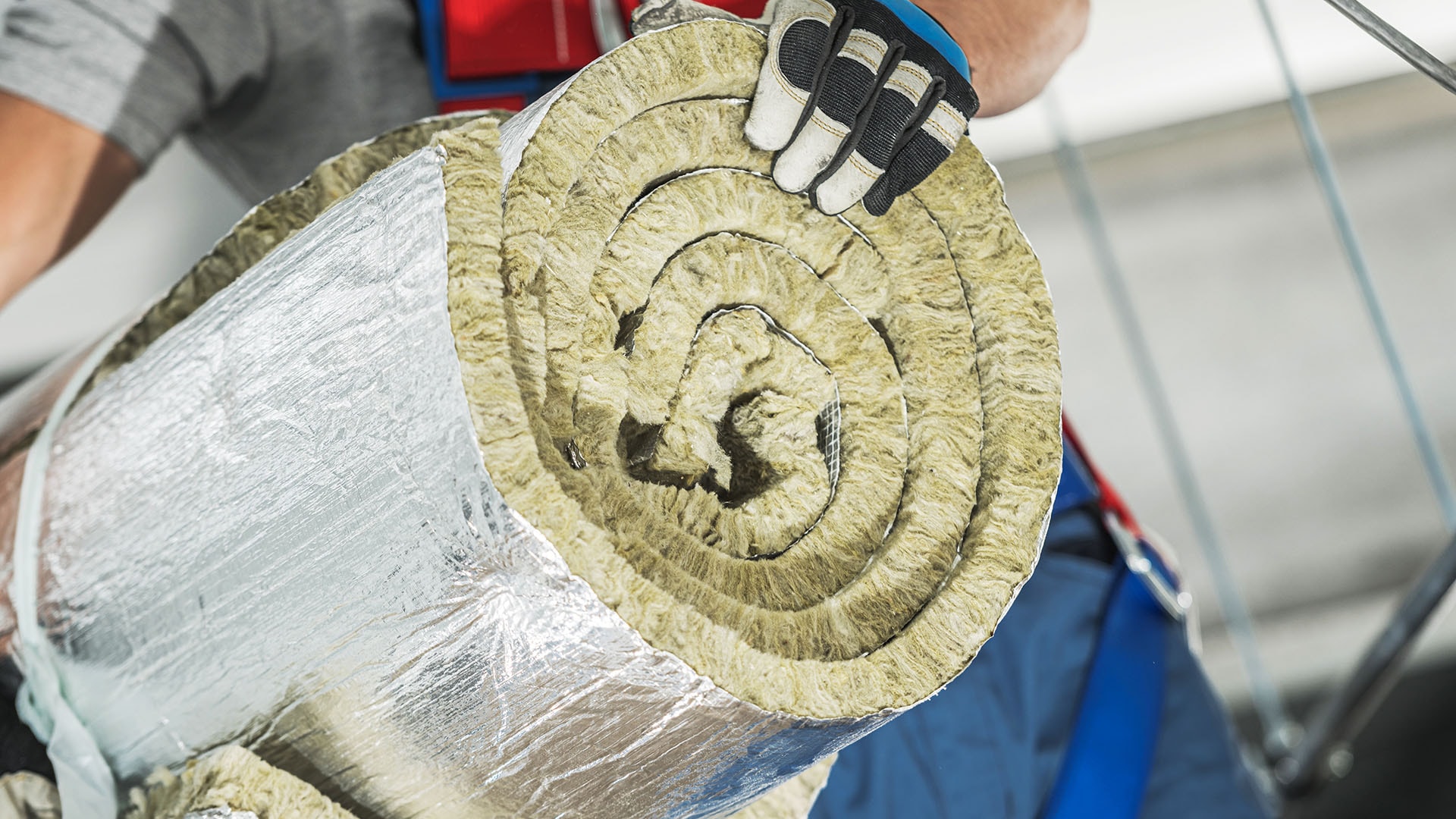 1920 työntekijä kantaa rullalla olevaa alumiinipinnoitteista eristettä