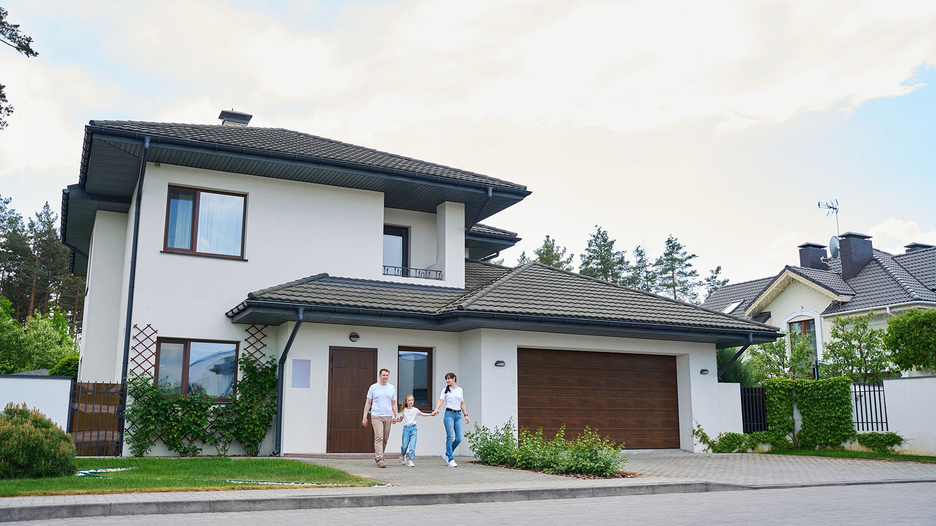 1920 vaaleaksi rapattu talo kadunvarrella etupihalla perhe