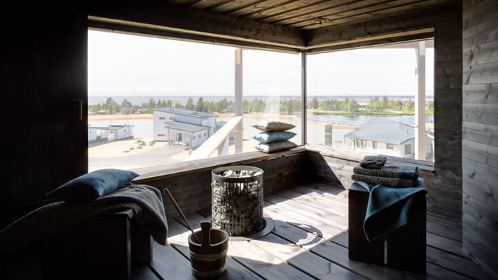 <p data-block-key="0ttjq">Tämän saunan lauteet on korvattu siirreltävillä jakkaroilla. Näin saunoja pääsee tarvittaessa kauemmas tasoon upotetusta kiukaasta. Seinissä sekä katossa on käsiteltyä kuusipaneelia.</p>