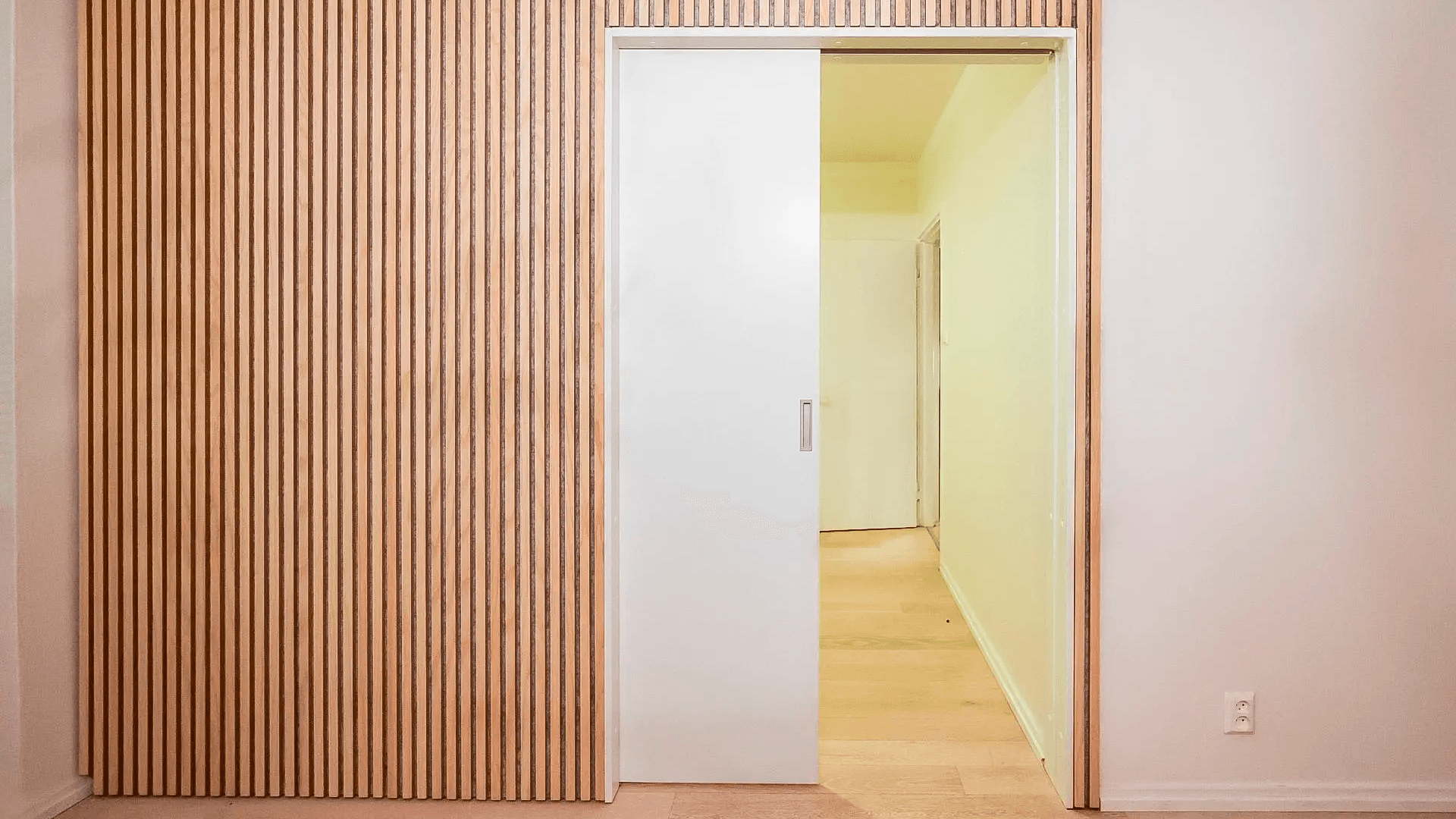 <p data-block-key="tcc9o">Saneerauselementti kiinnitetään aukkoon, sen ympärille levytetään uusi pinta ja paneelit viimeistelevät seinän yhtenäiseksi kokonaisuudeksi. Oleskelutilassa yksi iso vaimennuspinta auttaa usein enemmän kuin monta pientä. Sijoitus kannattaa tehdä sinne, missä ääni heijastuu eniten. (Kuva Aulis Lundell Oy)</p>