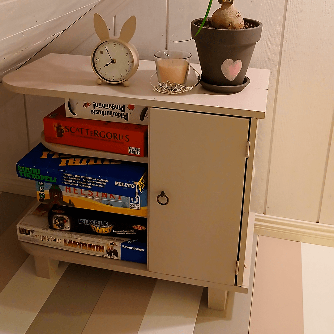 Kauniisti maalattu lautalattia sekä vanha kaappi täynnä pelejä