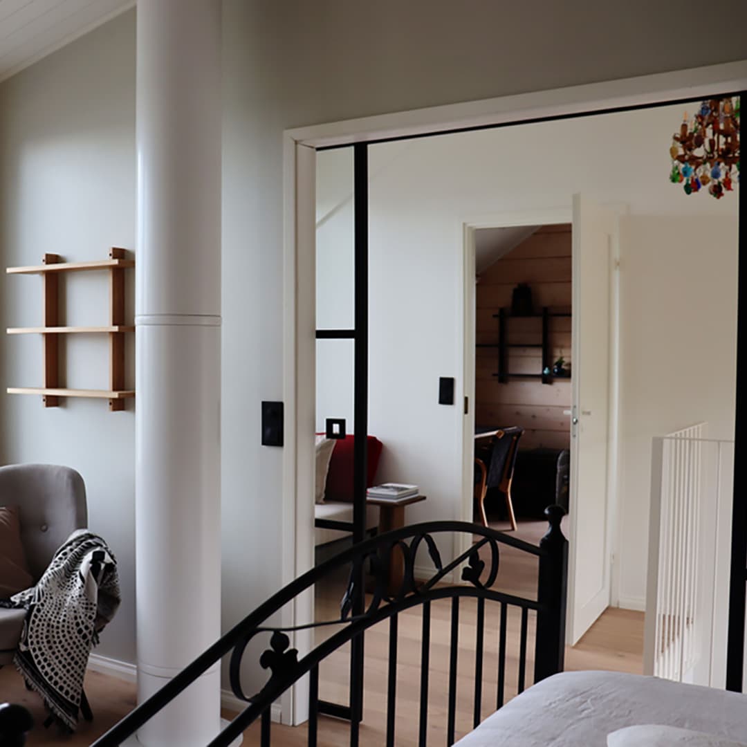 musta rautainen sängynpääty vaaleasti sisustetussa makuuhuoneessa