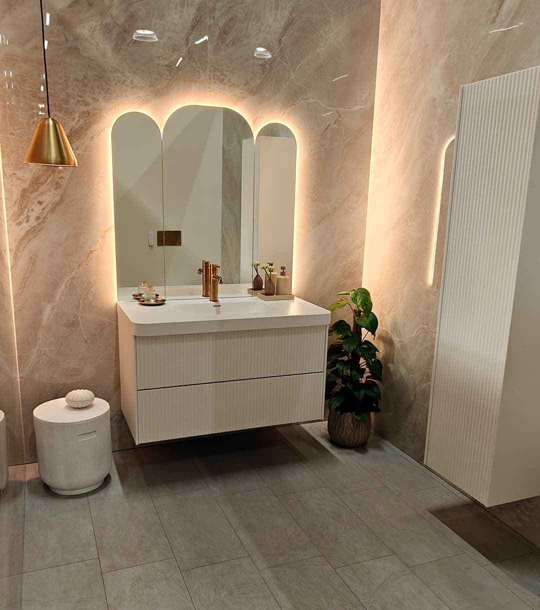 <p data-block-key="419y0">Kylpyhuoneessa kaarevat peilit, lämmin valo ja kivimäinen pinta tekevät ilmeestä ylellisen mutta hillityn. (Kuva Sari Nieminen)</p>