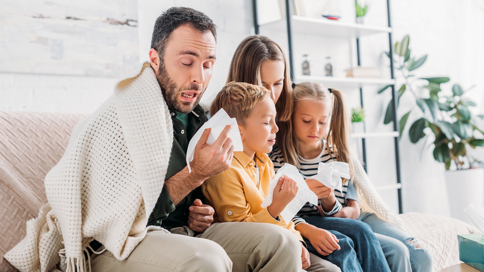 diseased-family-wrapped-in-blanket-sitting-on-so-2024-11-19-11-02-47-utc