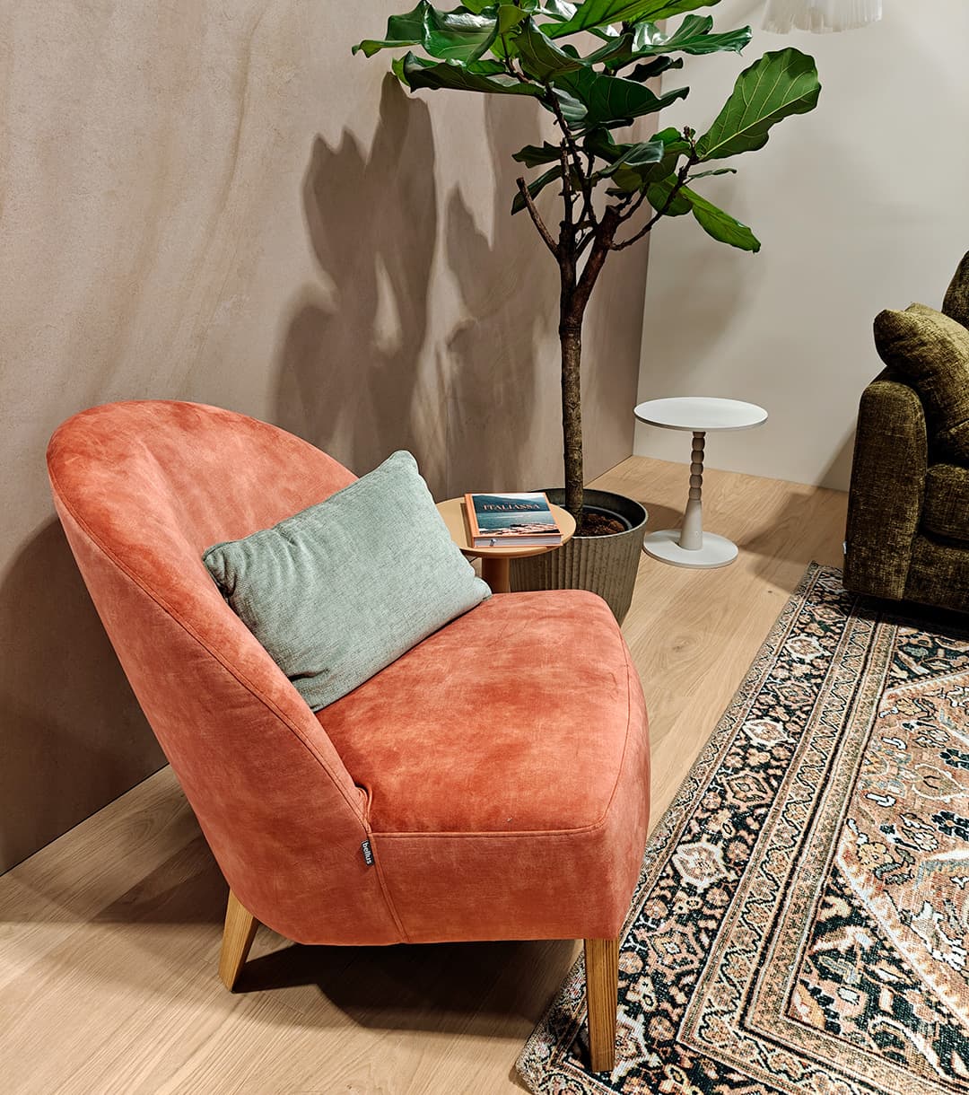 <p data-block-key="8cnd0">Persikan sävyinen nojatuoli pehmentää kokonaisuutta ja nostaa esiin tilan lämpimän värimaailman. (Kuva Sari Nieminen)</p>