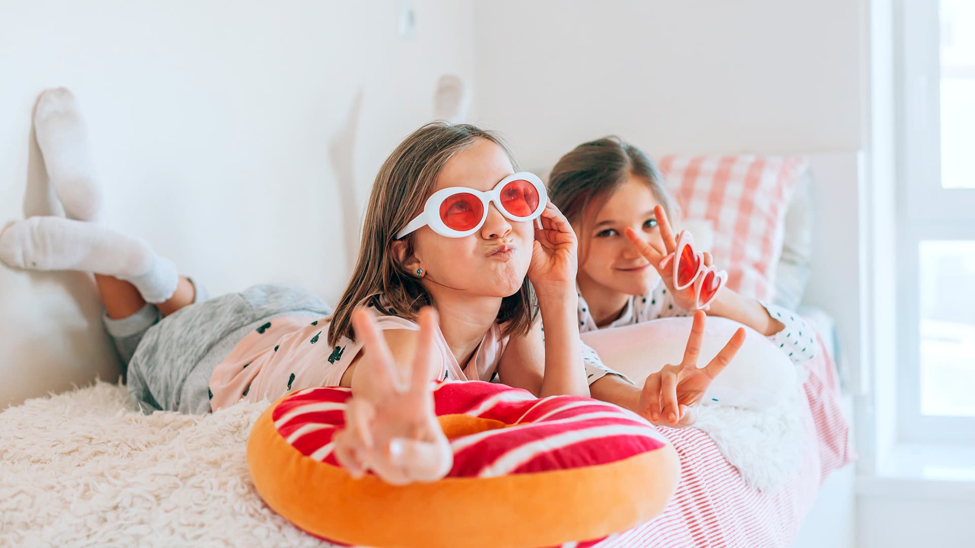 kaksi lasta makoilee sängyllä