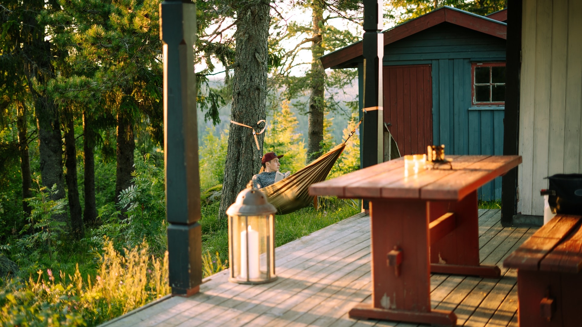 low-angle-shot-of-a-male-lying-on-a-hammock-readin