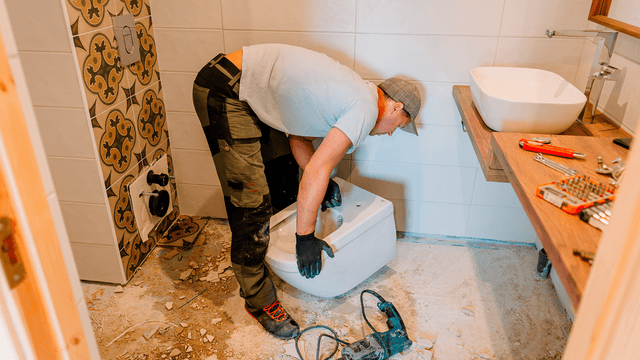 mies tekee kylpyhuoneremonttia ja purkaa vanhaa kylpyhuonetta