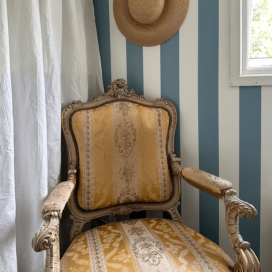 rokokoo tuoli, raidallinen tapetti ja olkihattu
