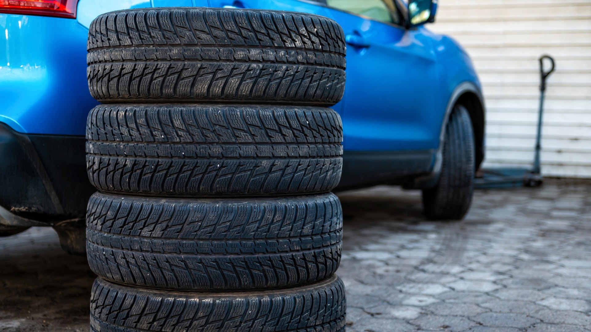 set-of-winter-tires-next-to-the-car-in-the-wheel-s