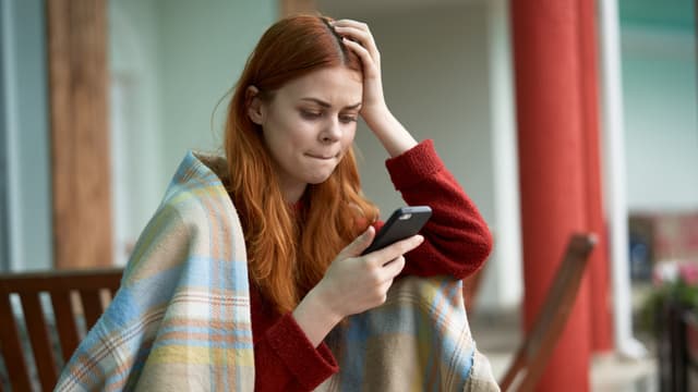 Nainen kylmissään viltin alla