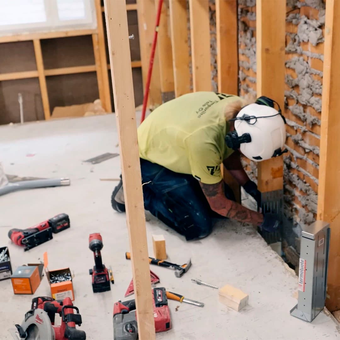 mikko merelä ja petja pessi seisovat talon sisällä josta on purettu kaikki ulkoseinään asti pois